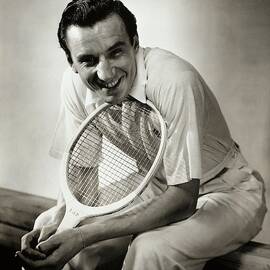 A Portrait Of Fred Perry With A Tennis Racket by Anton Bruehl