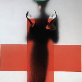 A Woman Standing Behind A Red Cross On Frosted by Erwin Blumenfeld