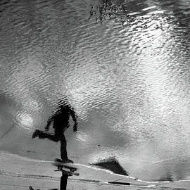 Skateboarder Reflection In Puddle by Mgs