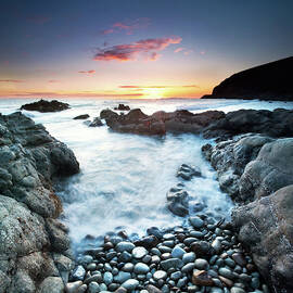 Sunset Over Sea With Pebbles In by John B. Mueller Photography